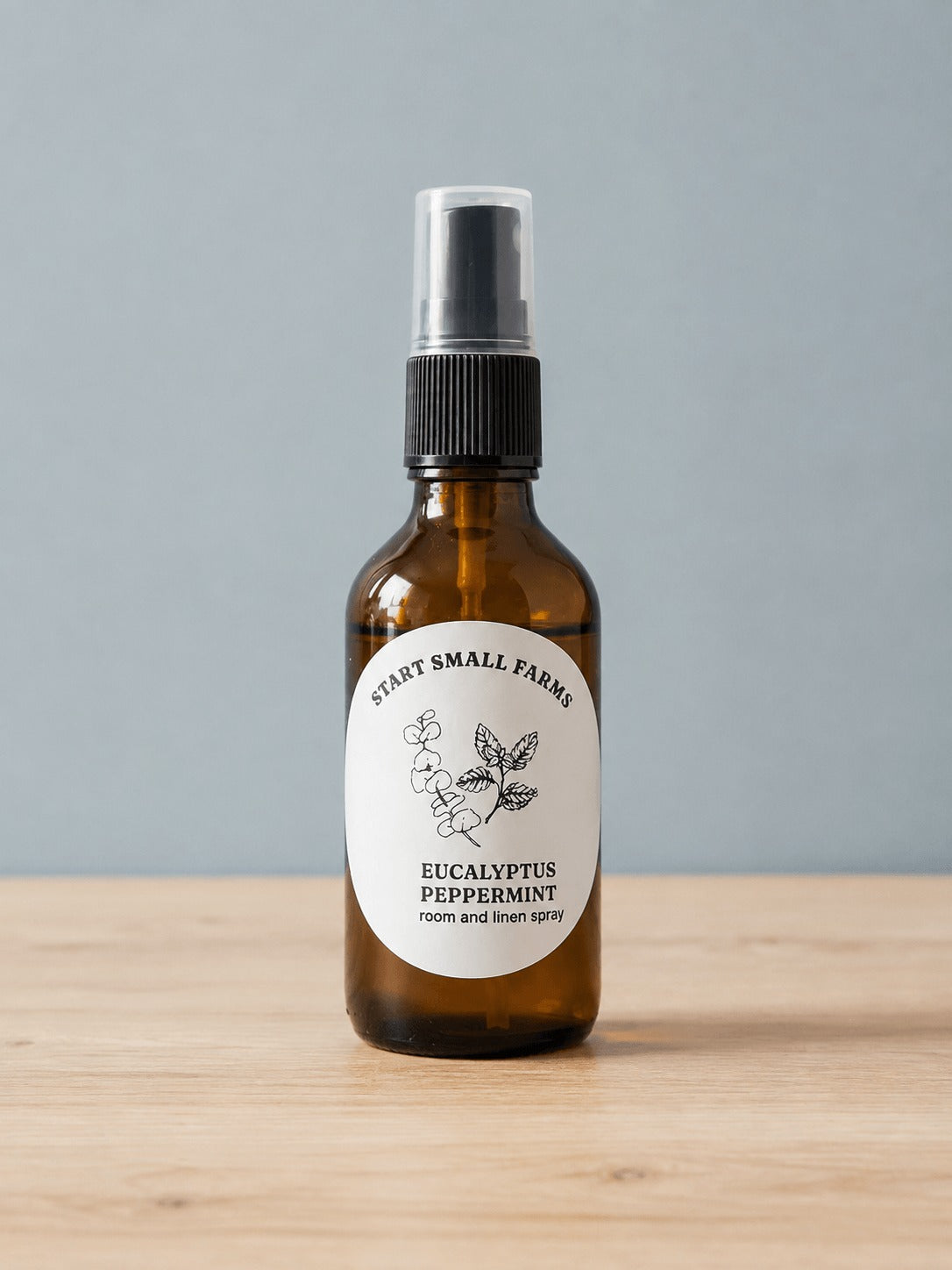 Room & Linen Spray in Eucalyptus Peppermint, a 4oz amber glass bottle with a black spray top