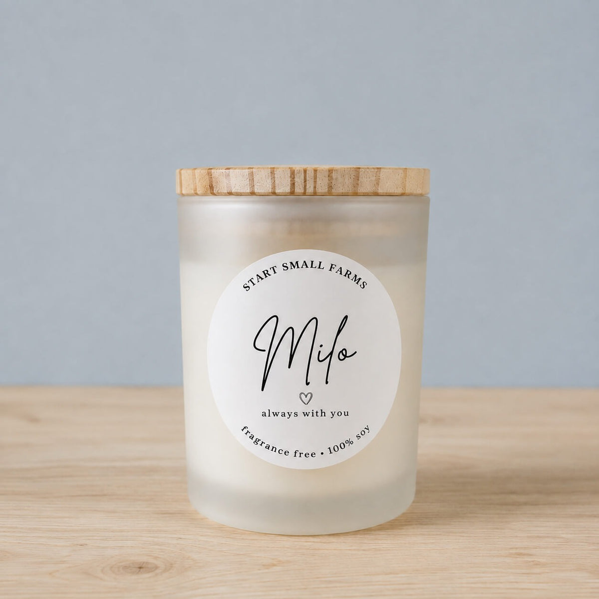 A frosted soy candle with a bamboo lid, labelled Milo, always with you, fragrance free, 100% soy