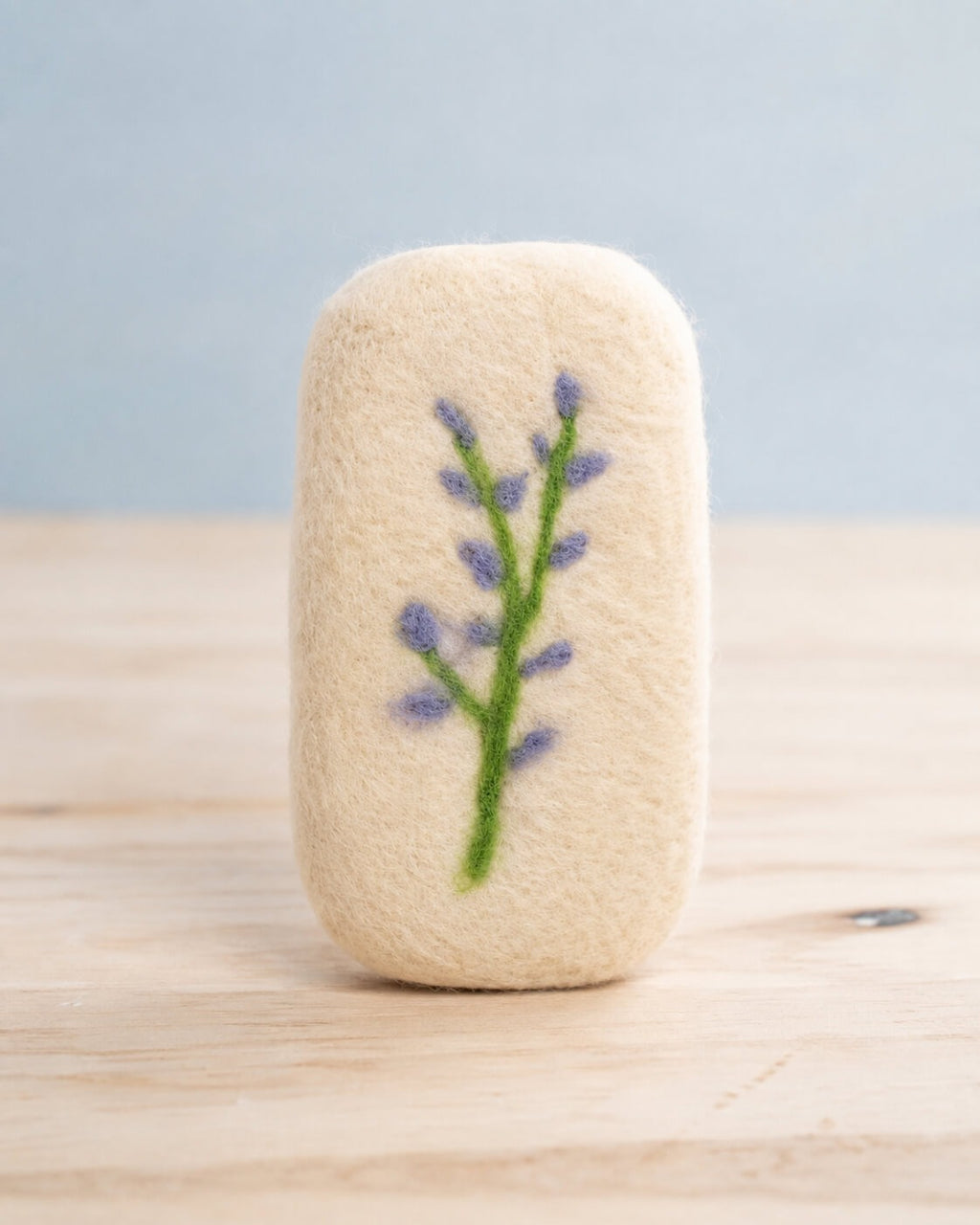A finished felted bar standing upright with a two stemmed lavender sprig needle felted into the front