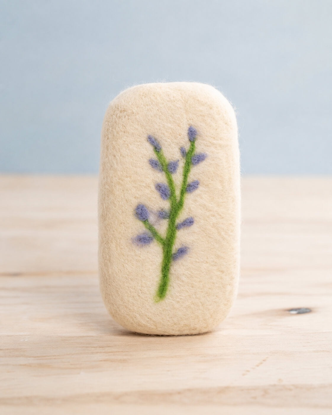 A finished felted bar standing upright with a two stemmed lavender sprig needle felted into the front