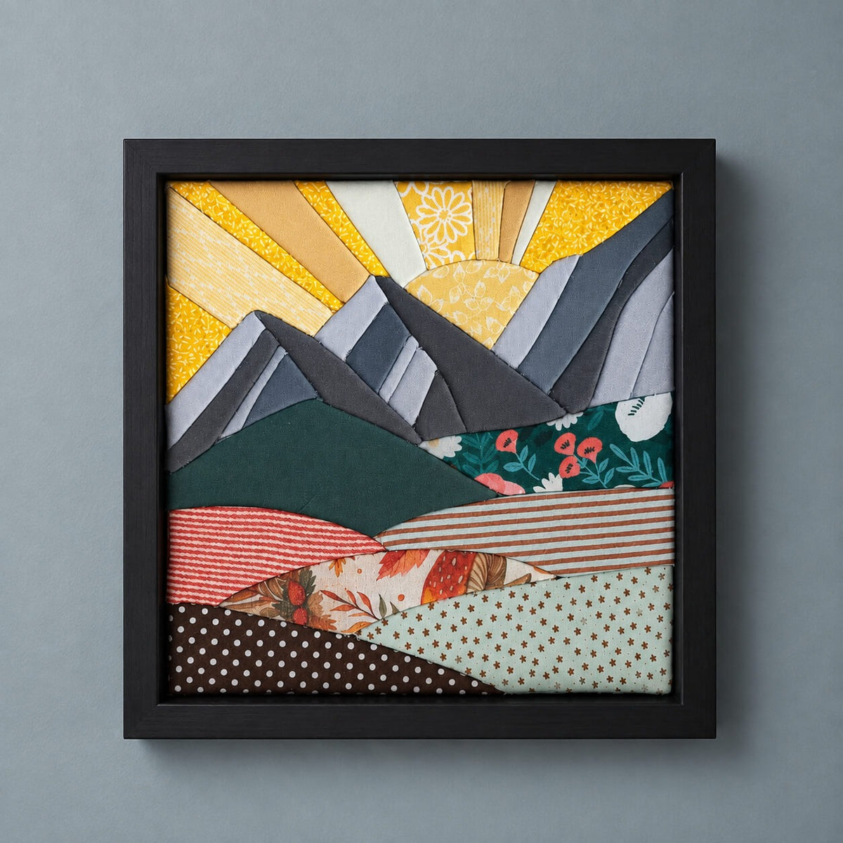 The same mountain design in a black frame, hanging flat against a grey-blue wall.