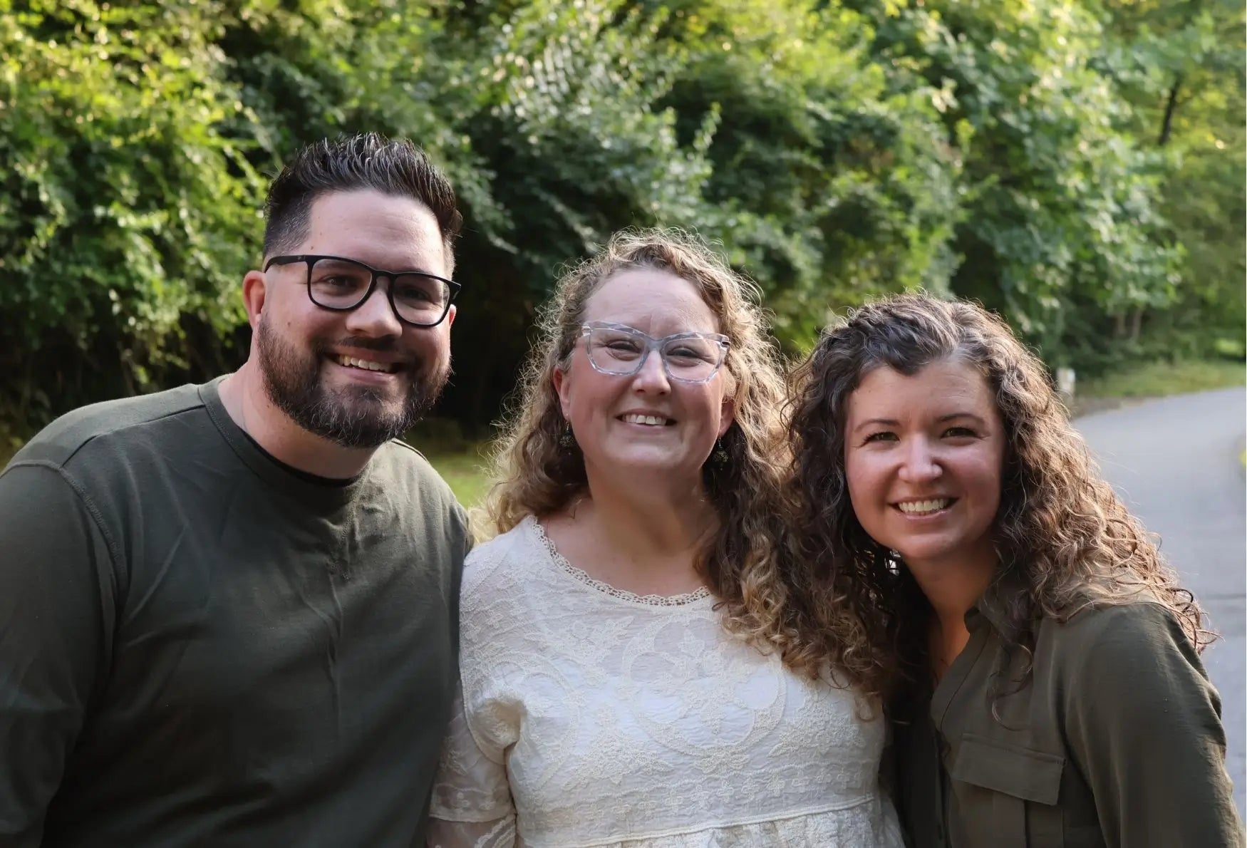 Photo of the Start Small Farms team - Jason, Niki, and Kim with trees in the background