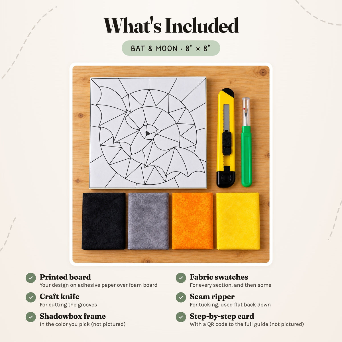 What's included in the Bat & Moon kit, laid out on a wood table: the printed board, fabric swatches, a craft knife and a seam ripper. The shadowbox frame and the step-by-step card are not pictured.