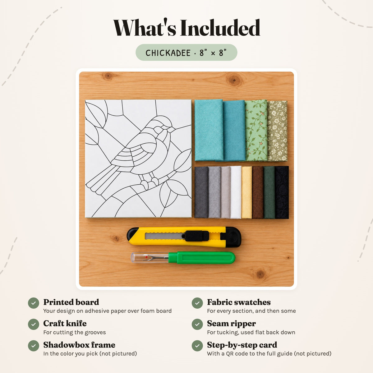 What's included in the Chickadee kit, laid out on a wood table: the printed board, fabric swatches, a craft knife and a seam ripper. The shadowbox frame and the step-by-step card are not pictured.
