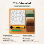 What's included in the Chunky Brown Bear kit, laid out on a wood table: the printed bear board, ten fabric swatches in greens and browns, a craft knife and a seam ripper. The shadowbox frame and the step-by-step card are not pictured.