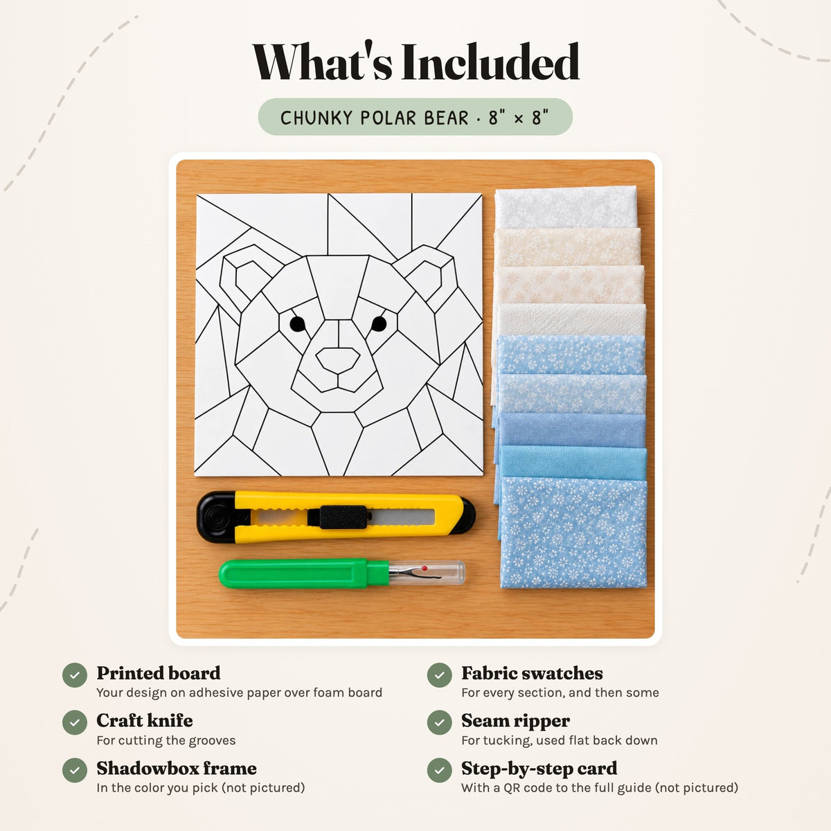 What's included in the Chunky Polar Bear kit, laid out on a wood table: the printed bear board, fabric swatches in whites, creams and icy blues, a craft knife and a seam ripper. The shadowbox frame and the step-by-step card are not pictured.