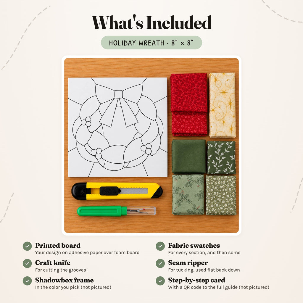 What's included in the Holiday Wreath kit, laid out on a wood table: the printed wreath board, fabric swatches in red, cream and gold, and greens, a craft knife and a seam ripper. The shadowbox frame and the step-by-step card are not pictured.
