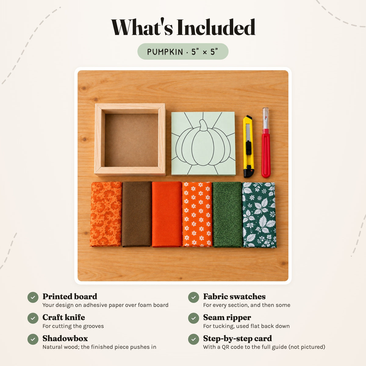 What's included in the Pumpkin kit, laid out on a wood table: the printed board, fabric swatches, a craft knife, a seam ripper and the natural wood shadowbox. The step-by-step card is not pictured.