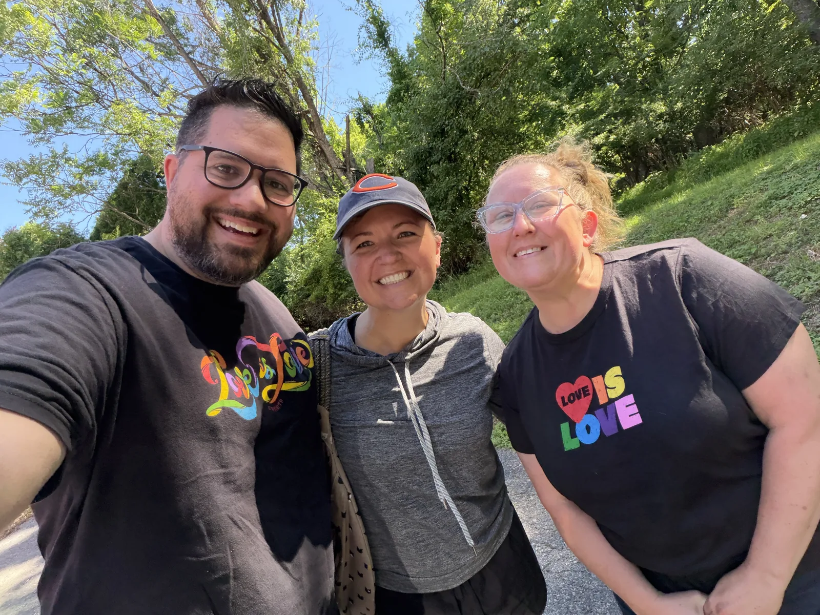 Jason, Niki, and Kim smiling together outside on a sunny walk.